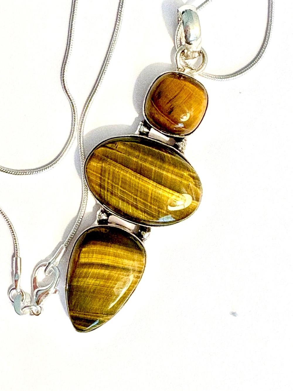 Beautiful 3 stone, 925 marked, Tiger Eye gemstone pendant on a silver chain.